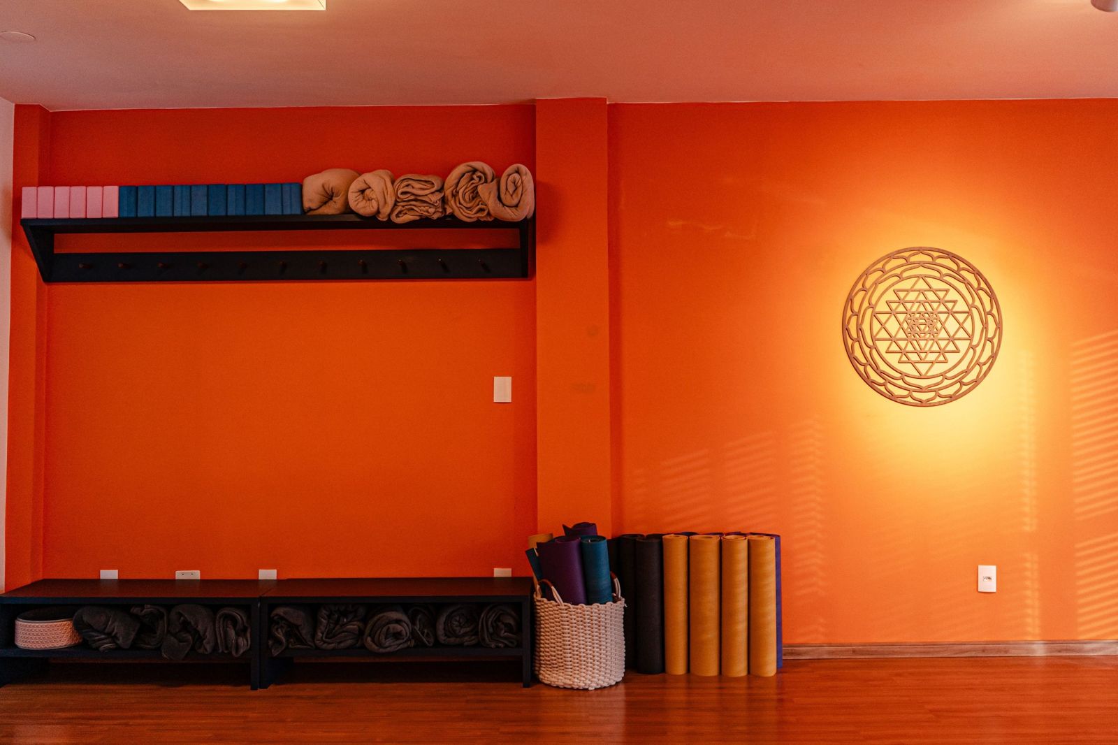 Prateleira com tapetes, blocos e mantas na sala da Surya